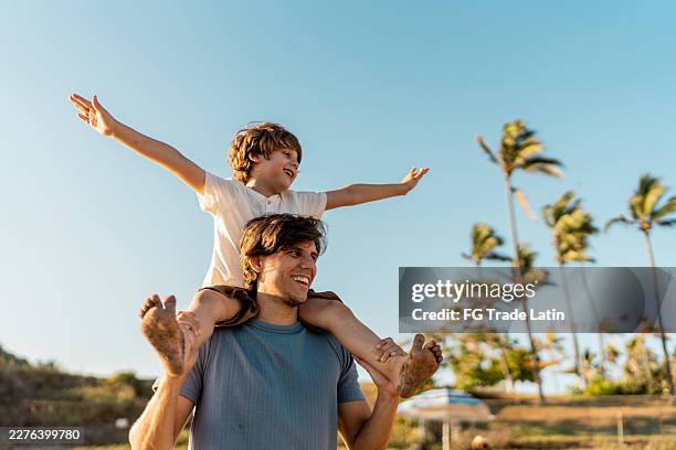 child boy playing with father on the beach - carrying on shoulders stock pictures, royalty-free photos & images