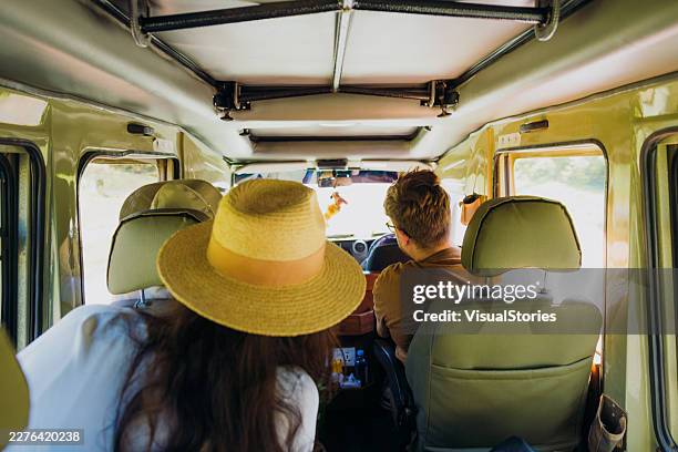 tourists driving in opened roof safari car through african savanna - masai mara national reserve stock pictures, royalty-free photos & images