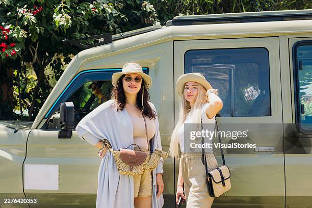 two cheerful handsome women enjoying safari trip by 4x4 car - masai mara national reserve stock pictures, royalty-free photos & images