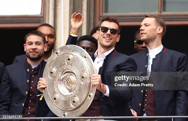 Leon Goretzka of FC Bayern Munich holds up the Bundesliga Meisterschale for the crowd during the official championships celebration at Marienplatz on...
