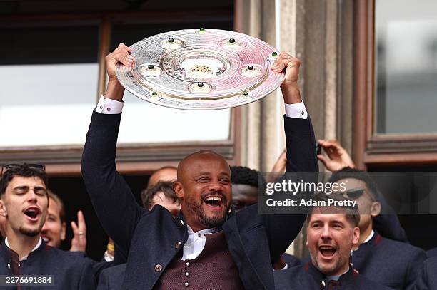 Vincent Kompany, Head Coach of FC Bayern Munich, holds up the Bundesliga Meisterschale for the crowd during the official championships celebration at...