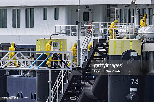 Health workers in orange hazmat suits board the Dutch polar expedition cruise ship. The Dutch polar expedition cruise ship MV Hondius sits moored at...