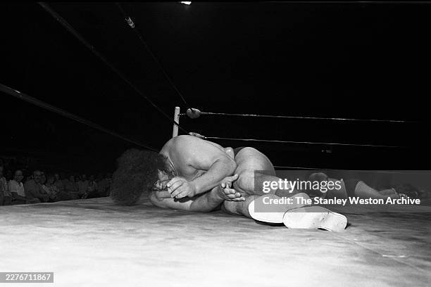 Andre The Giant vs Bruiser Brody. Andre The Giant and Bruiser Brody , lay on the mat during their wrestling match in Houston, Texas, June 10, 1977.