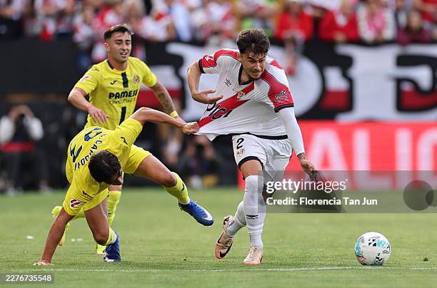 Andrei Ratiu of Rayo Vallecano is challenged by Sergi Cardona of Villarreal CF during the LaLiga EA Sports match between Rayo Vallecano de Madrid and...