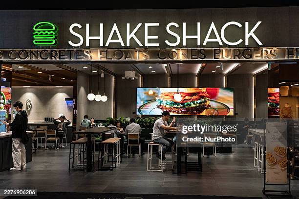 People eat hamburgers at Shake Shack in Seoul, South Korea, on May 21, 2026. Shake Shack is an American multinational fast casual restaurant chain...