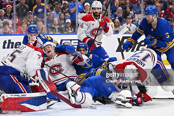 Jakub Dobes and Kaiden Guhle of the Montréal Canadiens defend the net against Zach Benson and Tage Thompson of the Buffalo Sabres during the second...