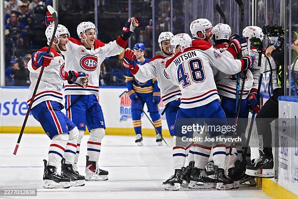 Alex Newhook of the Montréal Canadiens celebrates with teammates after scoring a goal against the Buffalo Sabres during overtime in Game Seven of the...