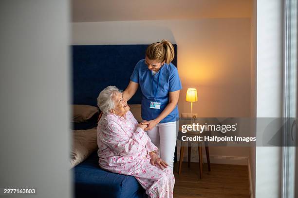 nurse talking with elderly man during home care visit. - house call stock pictures, royalty-free photos & images
