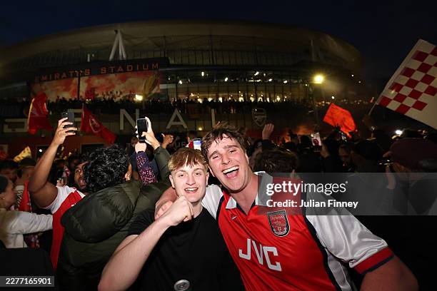 Fans of Arsenal celebrate as Arsenal are confirmed as Premier League champions following Manchester City's 1-1 draw against AFC Bournemouth, as they...