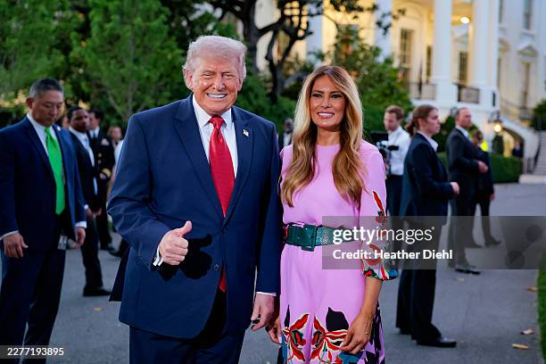 President Donald Trump and first lady Melania Trump pose for a photo in front of the White House press photographers during the congressional picnic...