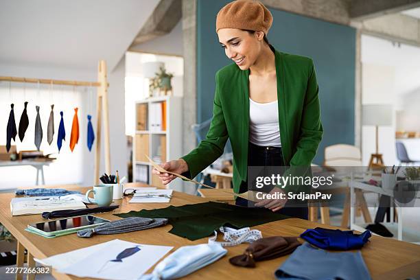 couturière créative souriante étudiant le modèle de cravate dans un atelier - industrie de la mode photos et images de collection