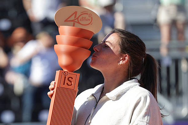 Emma Navarro kisses the trophy after beating Canada's Victoria Mboko to win their women's singles final tennis match on day 7 of the WTA 500...