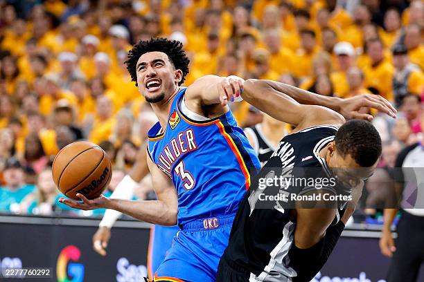 Jared McCain of the Oklahoma City Thunder looks to shoot the ball against Victor Wembanyama of the San Antonio Spurs during the third quarter in Game...