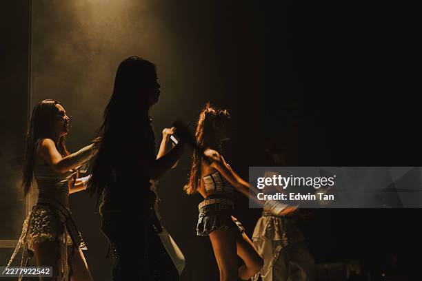 thai female pop group performing in warm golden haze with silhouetted singer, intimate stage moment, bangkok - pop music stock pictures, royalty-free photos & images