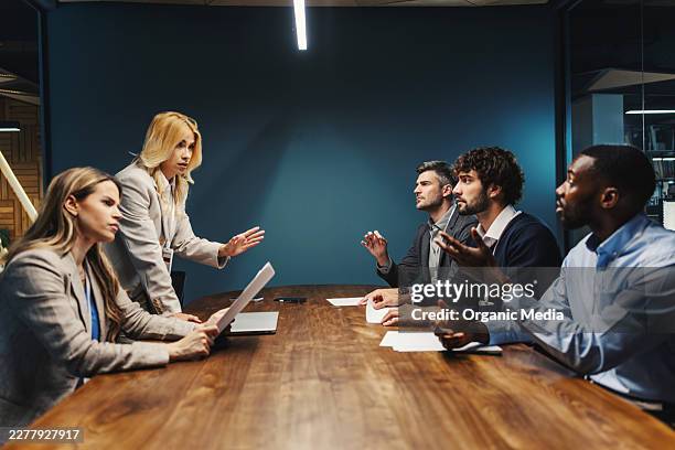professionisti del business che litigano durante una riunione - problemi di comunicazione foto e immagini stock