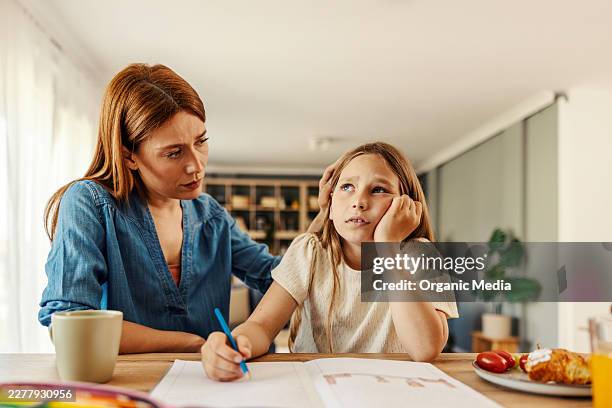 mother comforting daughter struggling with homework at home - struggle stock pictures, royalty-free photos & images