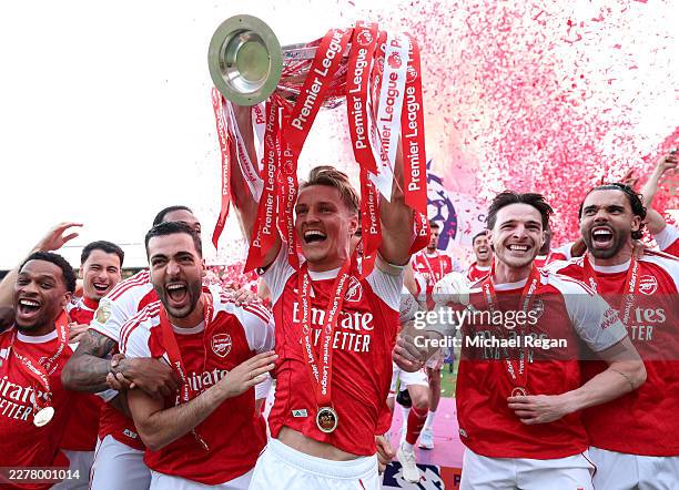 Martin Odegaard of Arsenal lifts the Premier League trophy as players of Arsenal celebrate, as they are crowned the Champions of the Premier League...