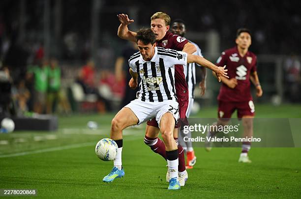 Andrea Cambiaso of Juventus is challenged by Marcus Holmgren Pedersen of Torino during the Serie A match between Torino FC and Juventus FC at Stadio...