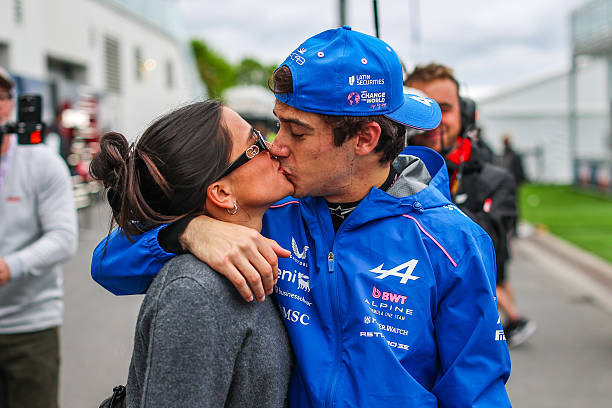 Franco Colapinto of Argentina and Alpine F1 Team shares a kiss with his girlfriend Maia Reficco in the paddock during the F1 Grand Prix of Canada at...