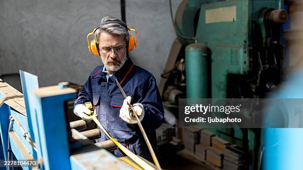 experienced technician measuring metal rod on precision manufacturing line in industrial workshop - safety equipment stock pictures, royalty-free photos & images