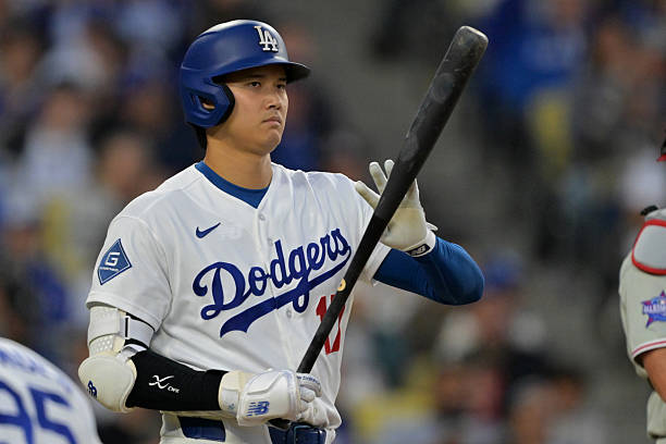 Shohei Ohtani of the Los Angeles Dodgers checks his bat as he approaches the plate in the third inning against the Philadelphia Phillies at Dodger...