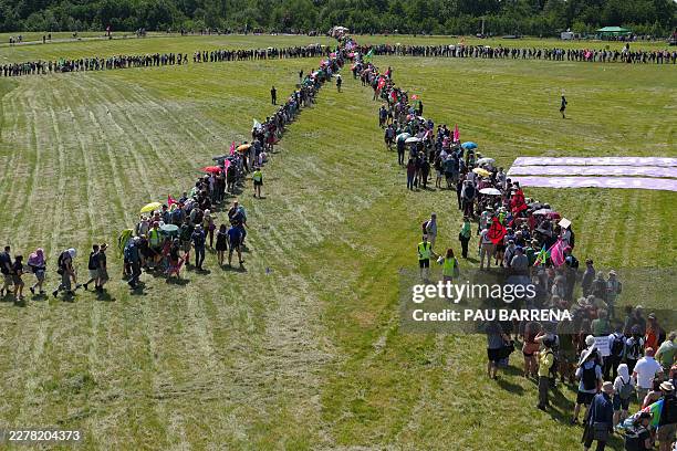 Demonstrators form a large human wind turbine as they take part in a demonstration under the motto "Future instead of gas Together for the energy...