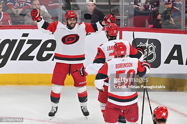 Shayne Gostisbehere of the Carolina Hurricanes is congratulated by Mark Jankowski and Eric Robinson after scoring a goal against the Montréal...