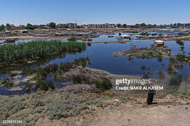 This aerial picture shows a man lookng at an inundated area in Raqa province following recent flooding as water levels rise along the Euphrates River...