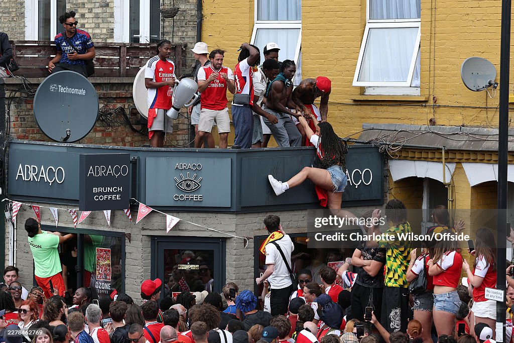 Arsenal Rooftop Arsenal fans help each other up onto a roof on Blackstock Road on May ...