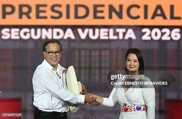 Peru's presidential candidates Keiko Fujimori, for the Fuerza Popular party, and Roberto Sanchez, for the Juntos por el Peru party, shake hands...