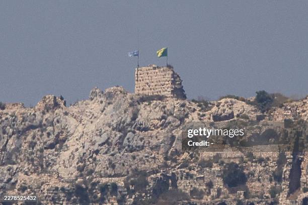 This picture taken from Marjayoun, southern Lebanon, shows an Israeli flag and a Golani Brigade flag fluttering atop the medieval Beaufort Castle in...