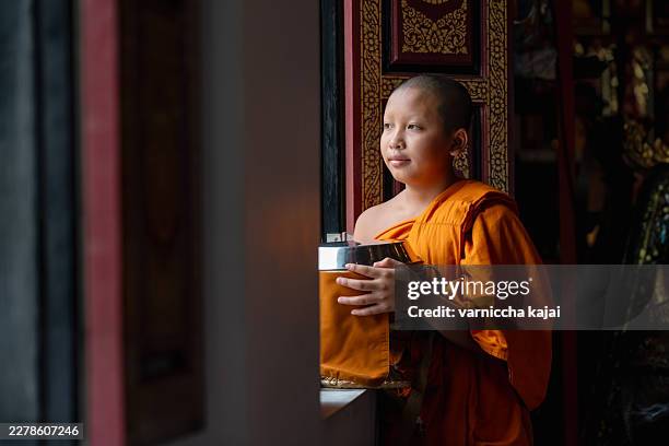 mönch denkt über das leben nach, buddhistisches tempelporträt, friedlicher innenraum, nah, spirituelle reise - buddhismus stock-fotos und bilder