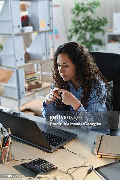 tired office worker looking worried while using laptop at desk - struggle stock pictures, royalty-free photos & images