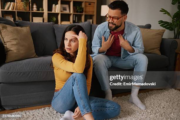 couple having conflict sitting on living room floor - passion stock pictures, royalty-free photos & images
