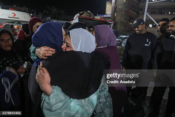 Palestinian women embrace as families reunite after the return of patients, wounded individuals and their companions to the Gaza Strip through the...