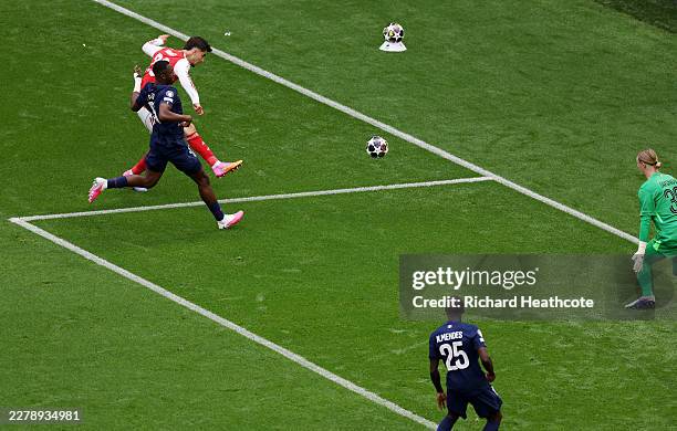 Kai Havertz of Arsenal scores his team's first goal while under pressure from William Pacho of Paris Saint-Germain during the UEFA Champions League...