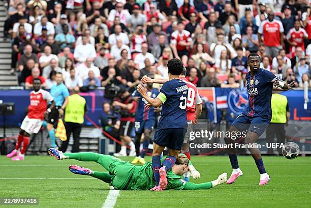 Matvey Safonov of Paris Saint-Germain punches clear a crossed ball from Bukayo Saka of Arsenal before going down injured during the UEFA Champions...
