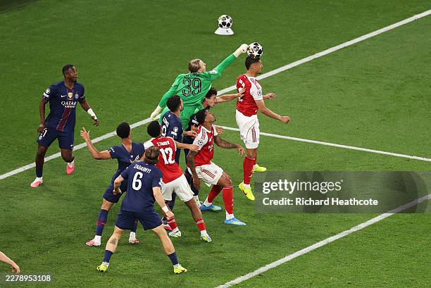 Matvey Safonov of Paris Saint-Germain attempts to make a save while under pressure from William Saliba of Arsenal during the UEFA Champions League...