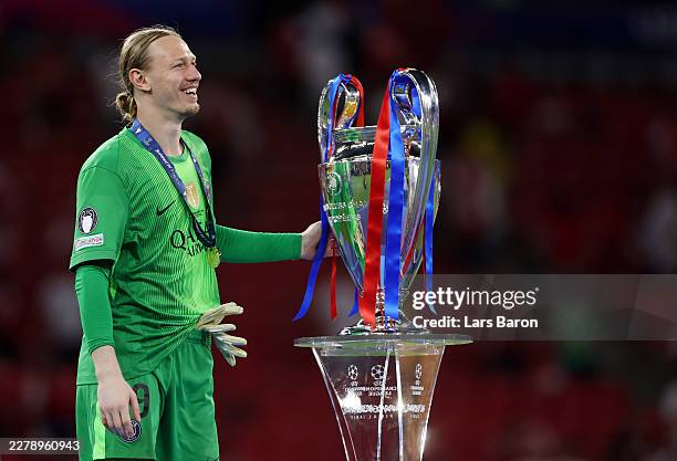 Matvey Safonov of Paris Saint-Germain touches with the UEFA Champions League trophy after he collects his winners medal following his team's victory...