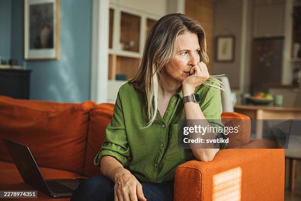 thoughtful woman reflecting on important life decisions at home - shy stock pictures, royalty-free photos & images