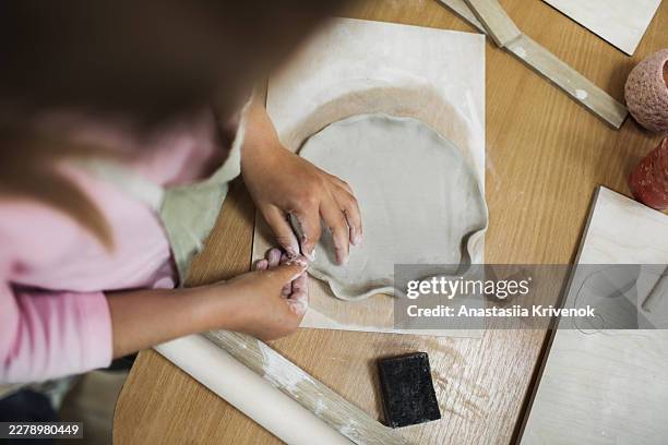 child making clay pottery with hands at wooden table in art class craft workshop - pinching stock pictures, royalty-free photos & images