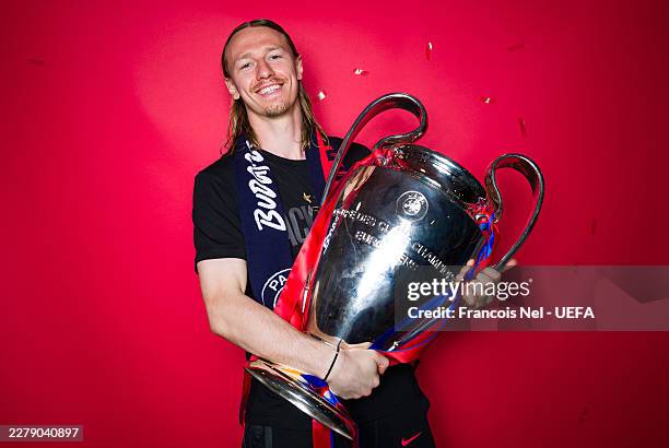 Matvey Safonov of Paris Saint-Germain poses for a portrait with the UEFA Champions League trophy after defeating Arsenal in the UEFA Champions League...