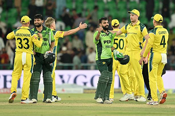 Pakistan's players Shadab Khan and Abdul Samad shake hands with Australia's players as they celebrate after winning the third One Day International...