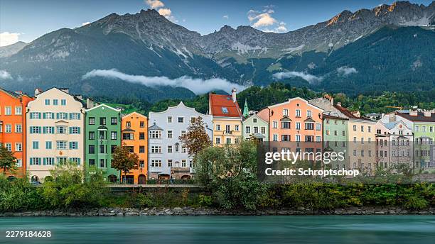 innsbruck austria colorful houses on river inn with alps in the background - innsbruck stock pictures, royalty-free photos & images