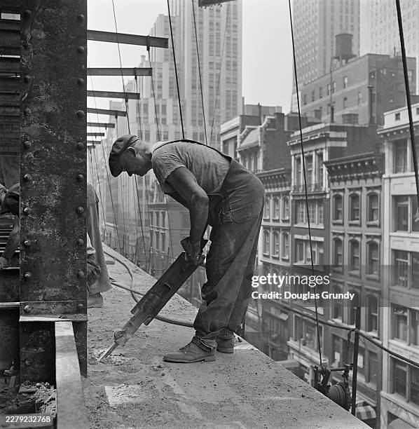 Demolition worker operating a jackhammer to remove a cornice ledge during the demolition of the Ritz-Carlton Hotel in New York City, May 1951.