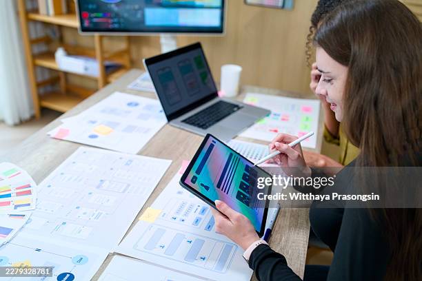 ux designer creating user interface wireframes and mobile application prototypes on a digital tablet with a stylus, collaborating with a colleague in a modern office - web prototype stock pictures, royalty-free photos & images