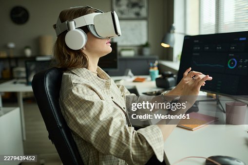Developer using AR goggles for virtual work at the office Developer using AR goggles for virtual work at the office