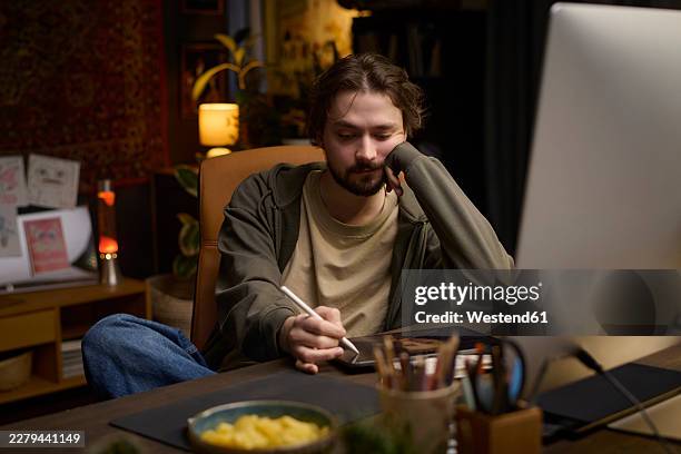 digital artist drawing on tablet at home workspace at night - designer computer screen stock illustrations