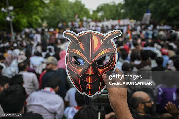 Cockroach Janta Party supporter holds a cockroach mask during a protest over alleged irregularities in the country's major examinations, in New Delhi...