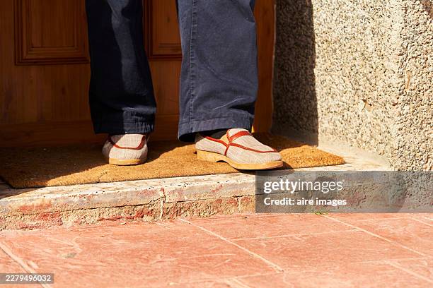 person standing on doormat entering or leaving home - front stoop stock pictures, royalty-free photos & images